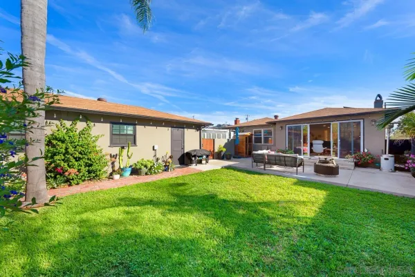 a view of a house with backyard and sitting area