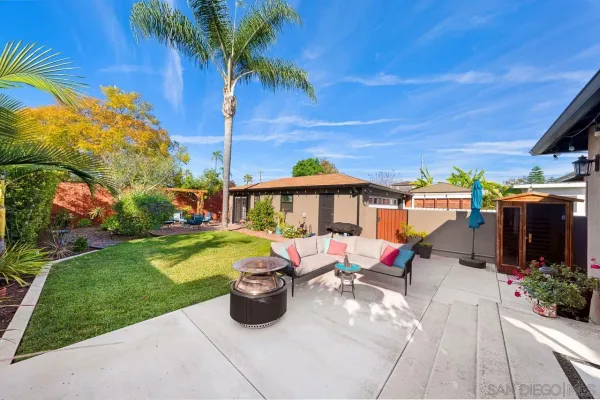 a view of a patio with table and chairs potted plants and palm trees