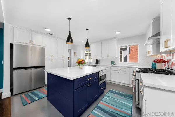 a kitchen with a sink a stove a refrigerator and white cabinets