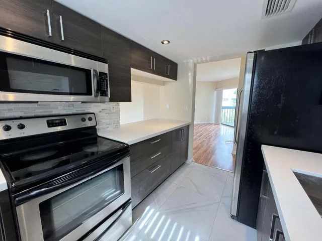 a large kitchen with a stove and a microwave