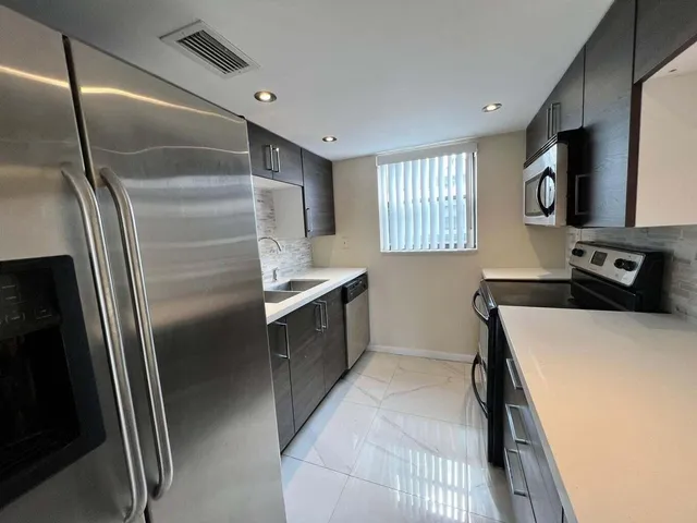 a kitchen with a refrigerator and a sink