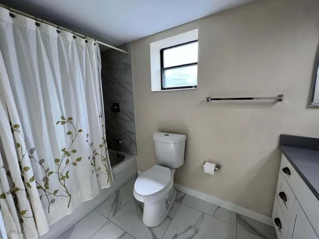 a white toilet sitting next to a shower curtain