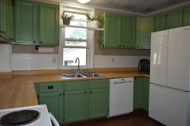 a white refrigerator freezer and a stove sitting inside of a kitchen