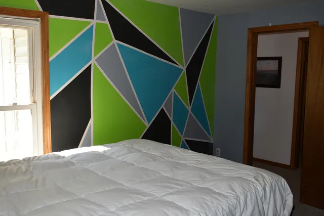 a view of a bedroom with wooden floor and a window