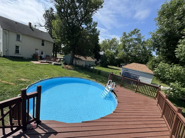 a view of a swimming pool with lawn chairs under an umbrella