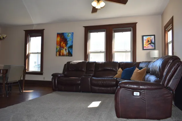 a living room with furniture two window and a dining table