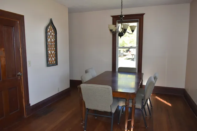 a view of an entryway with wooden floor and a kitchen