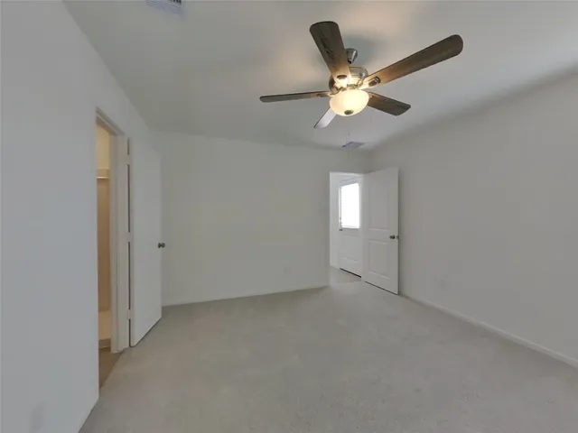 an empty room with closet and windows