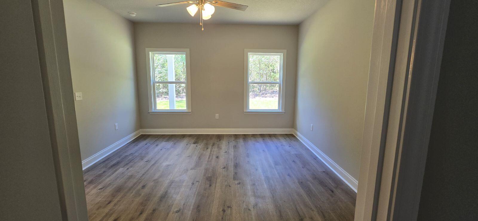 4500 Wolf Track Ridge Crestview, FL 32539 - Photo 11 of 19 an empty room with wooden floor and windows