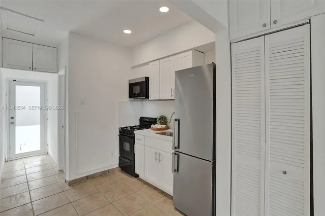 a kitchen with a refrigerator and a stove top oven