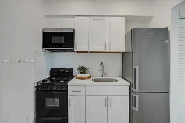 a kitchen with stainless steel appliances granite countertop a refrigerator and a stove top oven