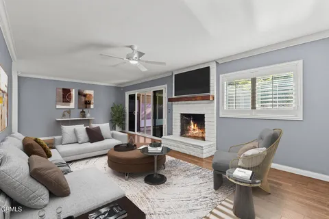 a large kitchen with stainless steel appliances kitchen island granite countertop a refrigerator a stove and white cabinets with wooden floor