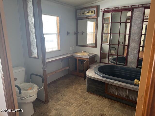 15 Brookwood Loop Adamsville, TN 38310 - Photo 3 of 9 a bathroom with a toilet a sink and a window