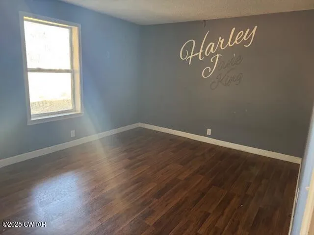 an empty room with wooden floor and window