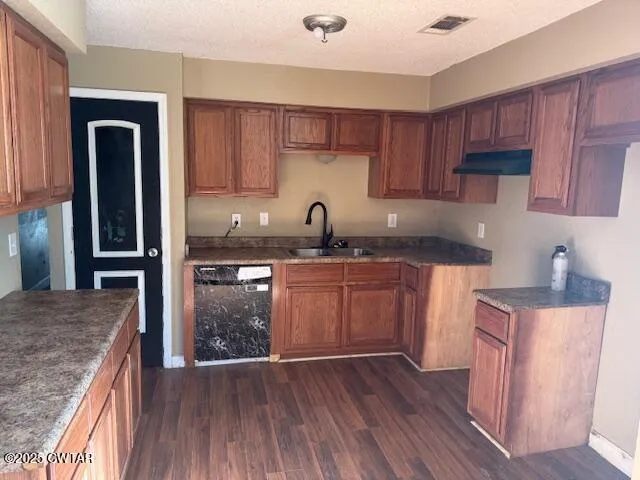 a kitchen with granite countertop wooden floors and wooden cabinets