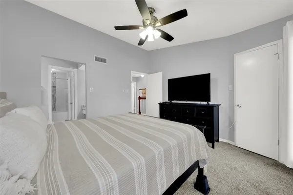 a bedroom with a bed and a flat tv screen on dresser