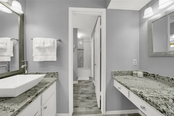 a bathroom with a granite countertop sink and a mirror
