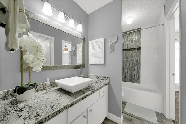 a bathroom with a granite countertop sink and a mirror