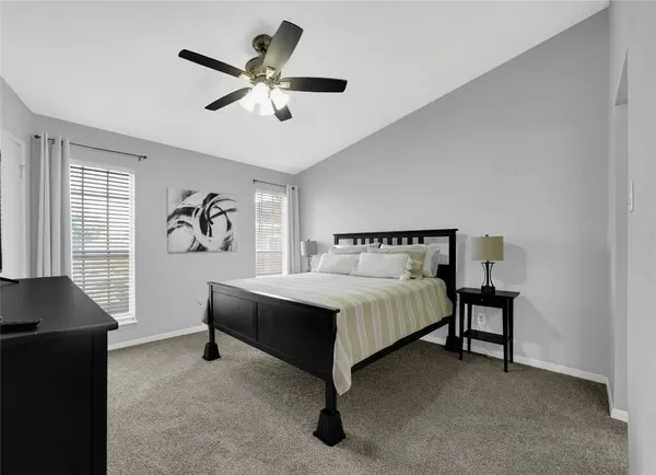 a spacious bedroom with a bed and a desk