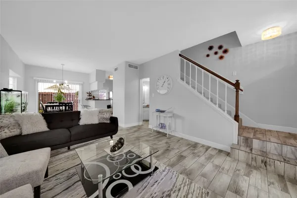 a living room with furniture and wooden floor