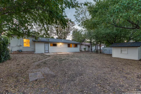a view of a house with a yard and a tree