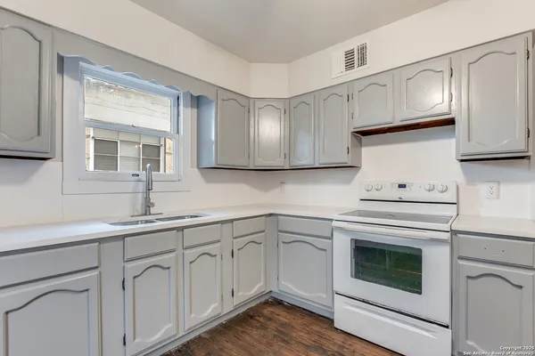 a kitchen with white cabinets stainless steel appliances and sink