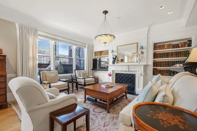a living room with furniture a fireplace and a chandelier