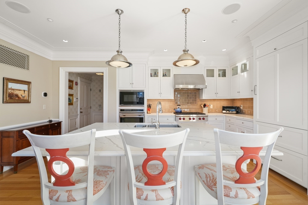 45-47 Commonwealth Avenue, Unit 5 Boston, MA 02116 - Photo 9 of 19 a kitchen with stainless steel appliances granite countertop a stove a sink dishwasher a dining table and chairs with wooden floor