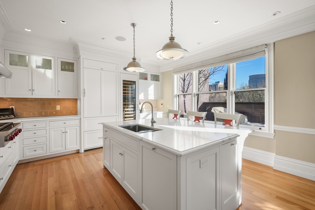 45-47 Commonwealth Avenue, Unit 5 Boston, MA 02116 - Photo 10 of 19 a large kitchen with kitchen island a sink stainless steel appliances and cabinets