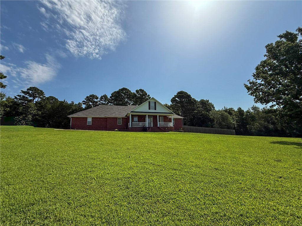 70 Walthall Road Russellville, AR 72802 - Photo 38 of 51 Red brick home with a white columned front porch, set on an expansive lawn with mature trees bordering the property