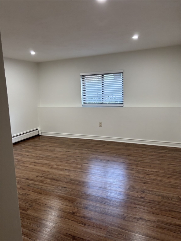 146 Willow Street, Unit 4 Waltham, MA 02453 - Photo 11 of 13 an empty room with wooden floor and windows