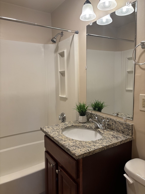 146 Willow Street, Unit 4 Waltham, MA 02453 - Photo 13 of 13 a bathroom with a granite countertop sink and a mirror