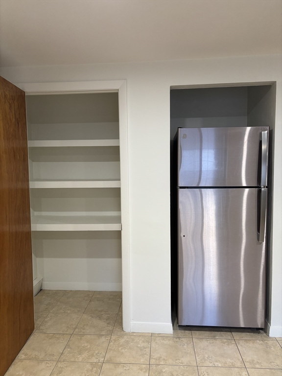 146 Willow Street, Unit 4 Waltham, MA 02453 - Photo 8 of 13 a view of a refrigerator in kitchen and empty room