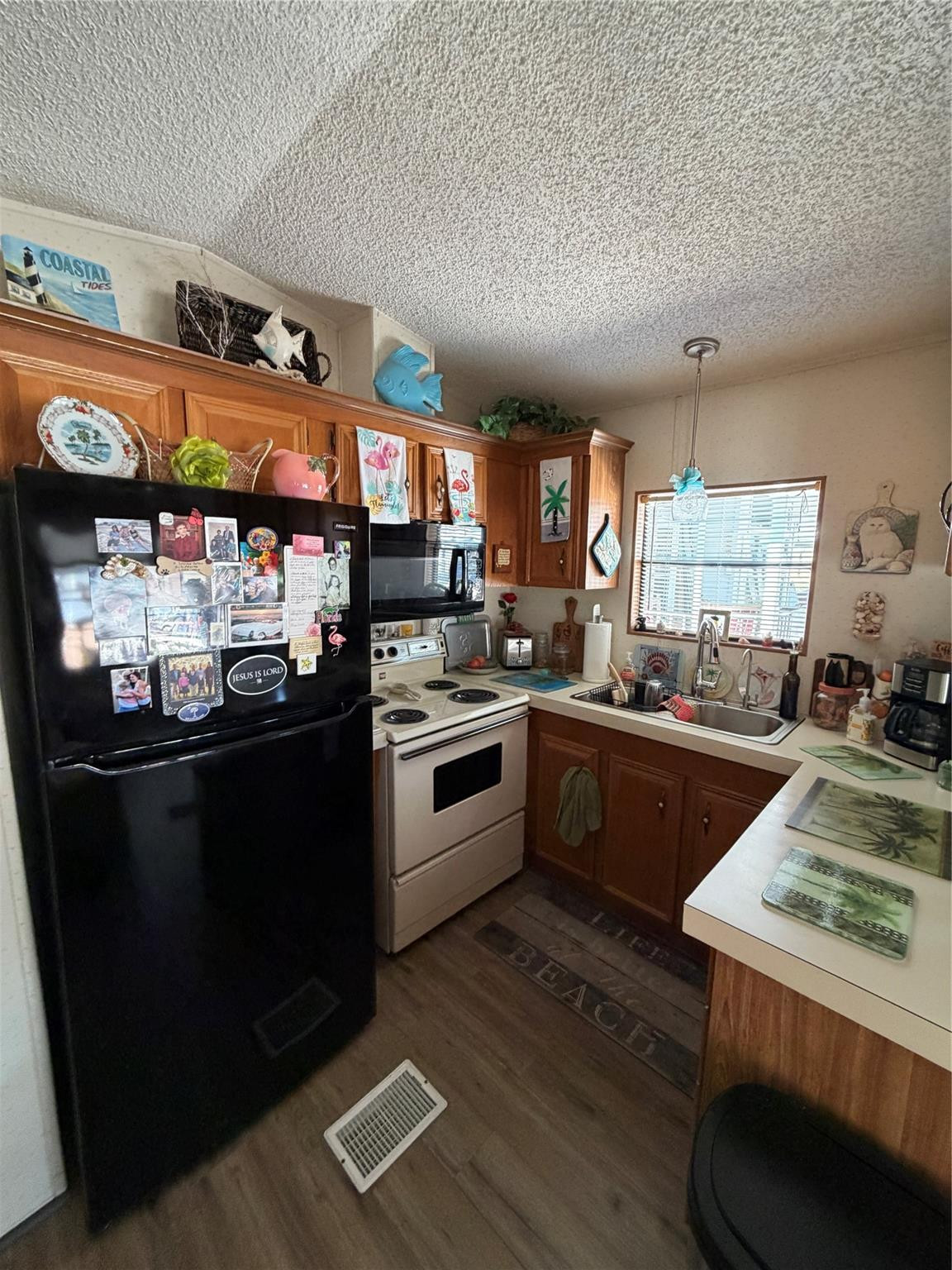 6444 Southeast 56th Street Okeechobee, FL 34974 - Photo 5 of 13 a kitchen with a stove a sink and a refrigerator