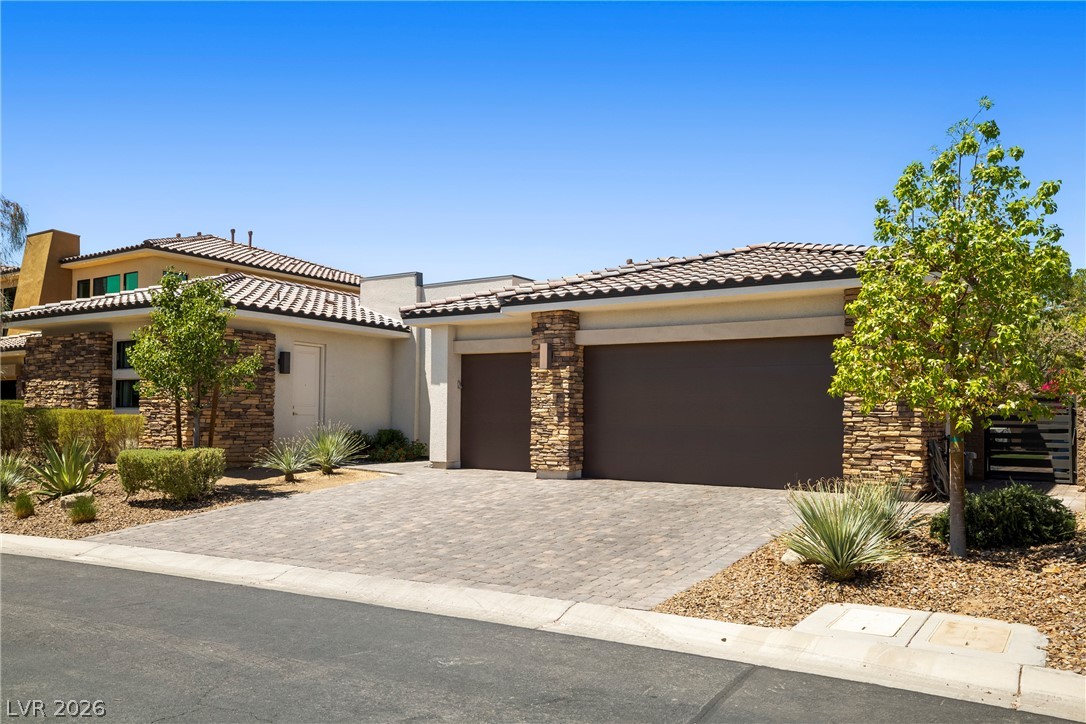 45 Garibaldi Way Henderson, NV 89011 - Photo 27 of 74 A desert-friendly landscape accents the appealing tiled roof and stone accents of this modern home.