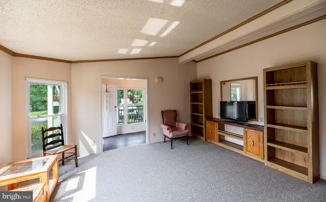 a living room with furniture a flat screen tv and a window
