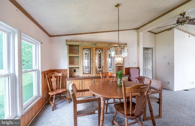 a dining room with furniture a chandelier and window