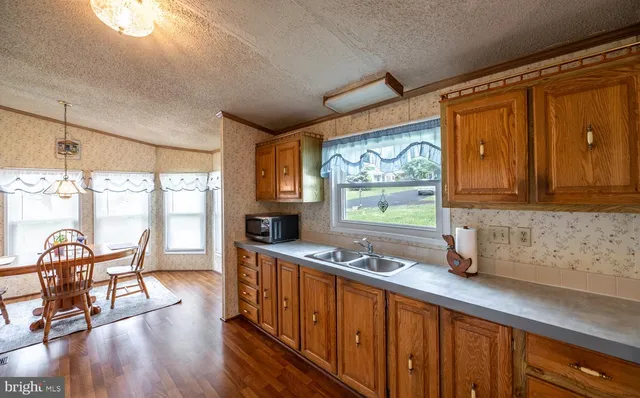 a kitchen with granite countertop a stove a sink and wooden floors