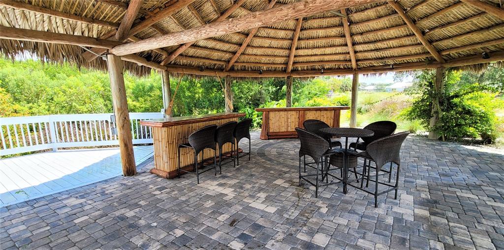 2049 Treasure Lane Punta Gorda, FL 33982 - Photo 70 of 72 a view of a patio with table and chairs under an umbrella with a big yard