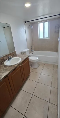 a bathroom with a granite countertop sink a toilet and mirror