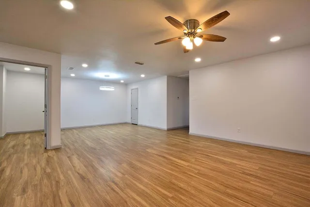 a view of an empty room with wooden floor