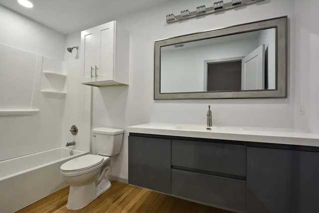 a bathroom with a toilet a sink and mirror
