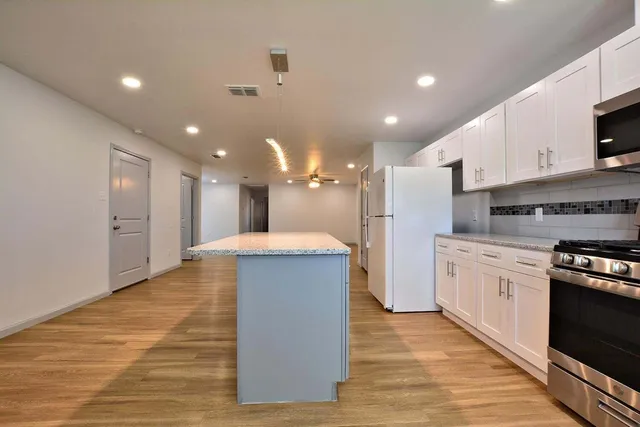 a kitchen with kitchen island a sink stainless steel appliances and cabinets