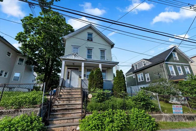 a front view of a house with plants