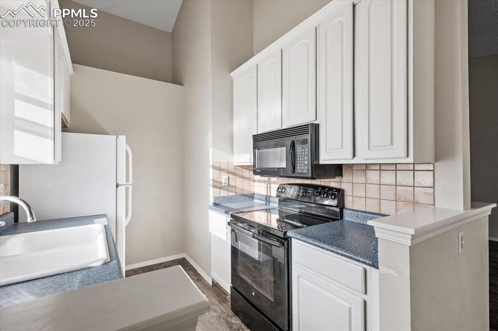 2531 Blazek Loop Colorado Springs, CO 80918 - Photo 4 of 29 a kitchen with stainless steel appliances granite countertop a sink stove and microwave