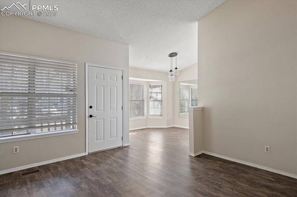 2531 Blazek Loop Colorado Springs, CO 80918 - Photo 6 of 29 a view of an empty room with wooden floor and a window