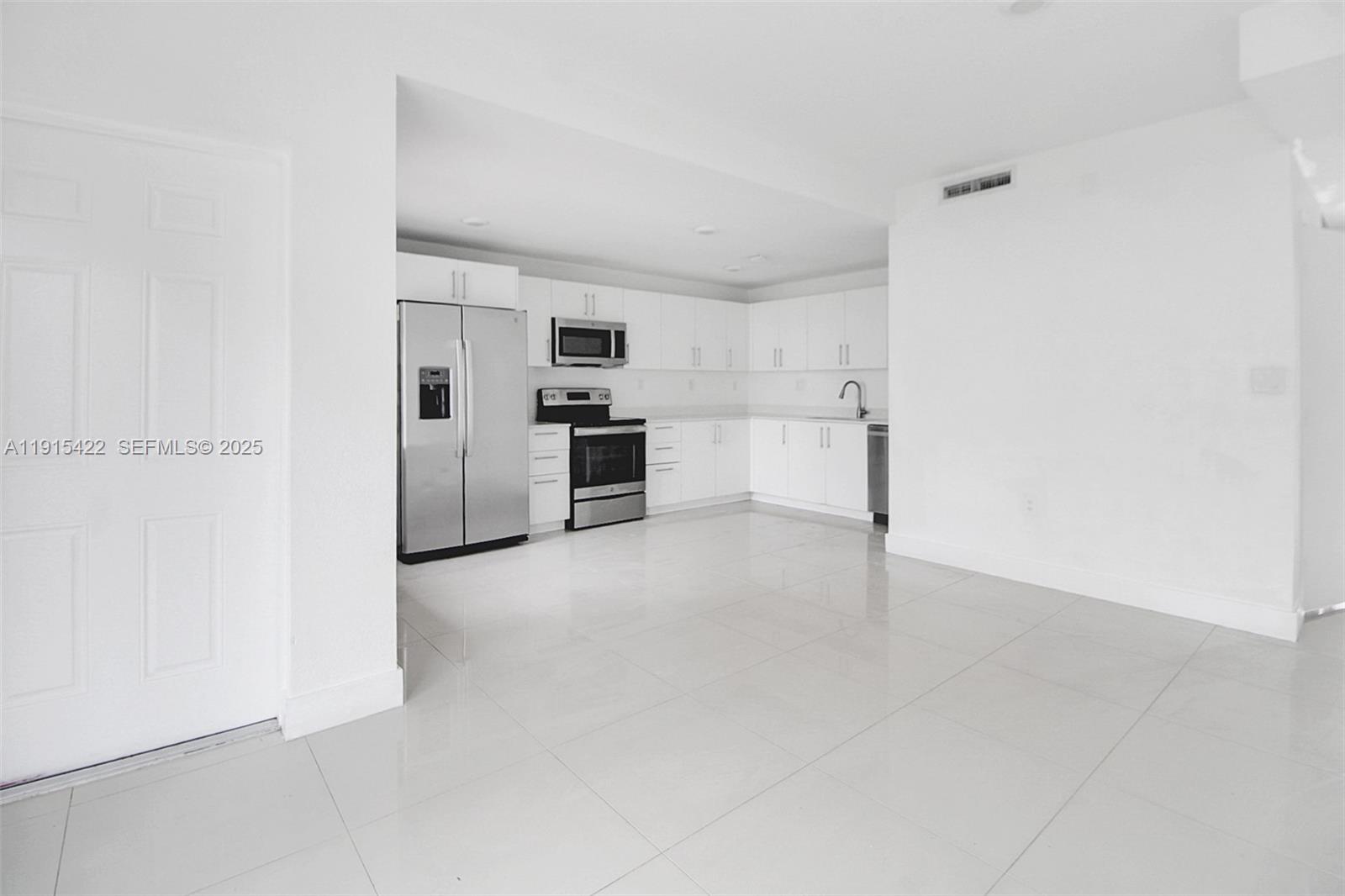 14482 Southwest 259th Street Homestead, FL 33032 - Photo 4 of 35 a view of a kitchen with refrigerator and window