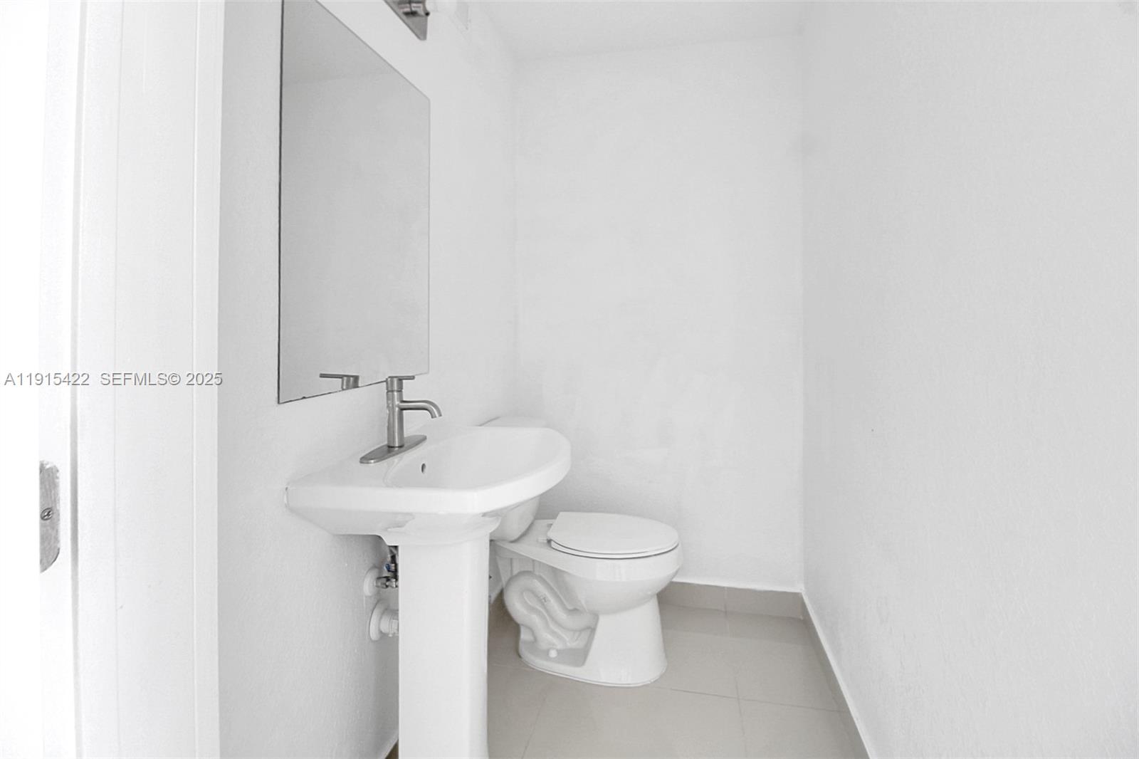 14482 Southwest 259th Street Homestead, FL 33032 - Photo 9 of 35 a bathroom with a sink a toilet and mirror