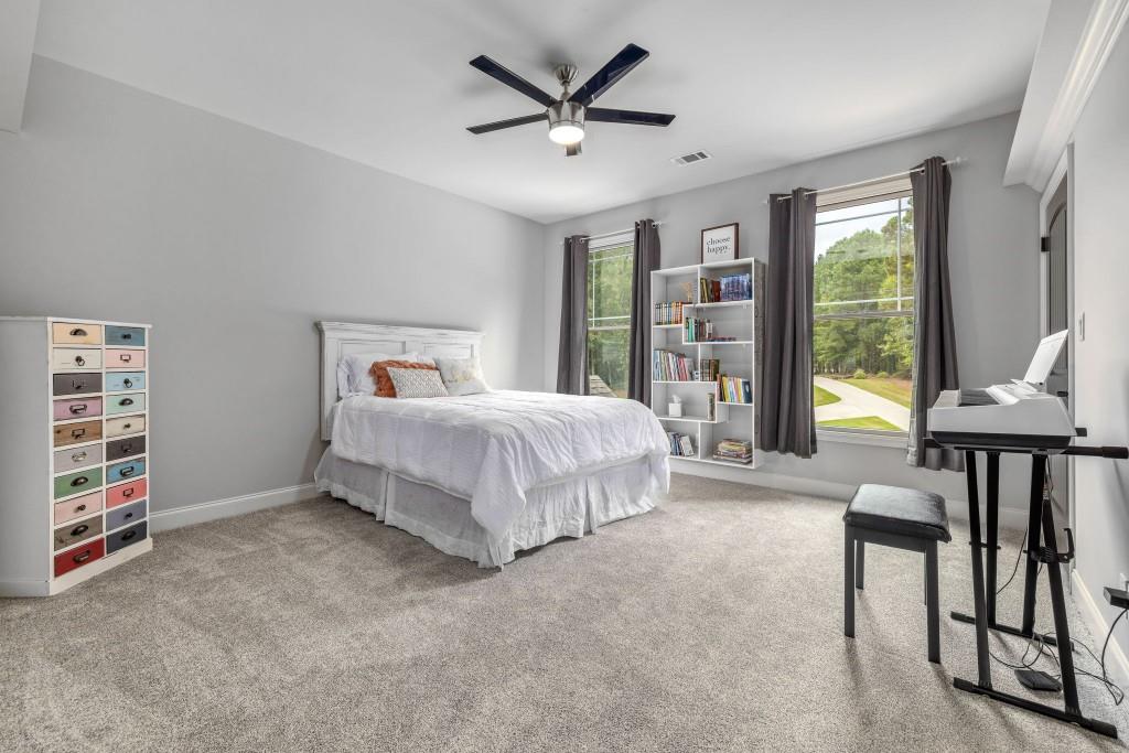 400 Harmony Road Eatonton, GA 31024 - Photo 55 of 136 a bedroom with a bed a chandelier and a book shelf