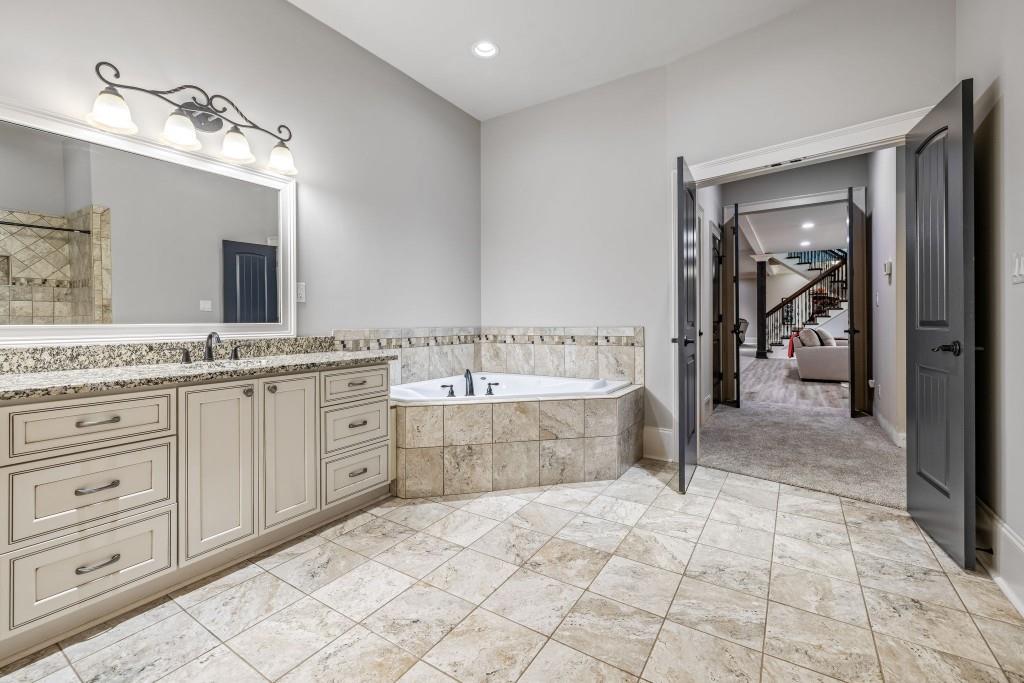 400 Harmony Road Eatonton, GA 31024 - Photo 75 of 136 a spacious bathroom with a granite countertop sink a mirror and a bathtub